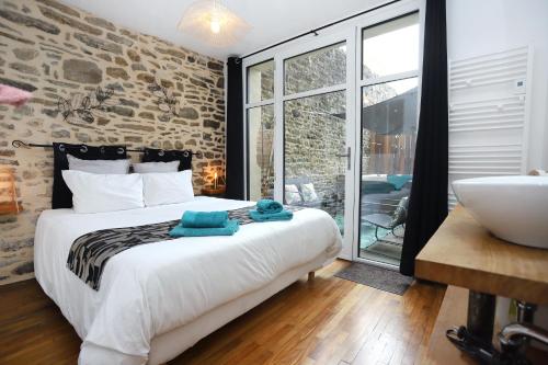 une chambre avec un lit et une salle de bain avec un lavabo dans l'établissement La chouette détente, à Fougères