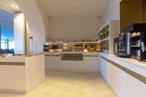 a large kitchen with white counters and appliances at Hotel Giosue' a mare Sorrento in Meta
