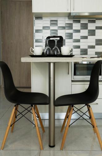 a table in a kitchen with two black chairs at Menta Studios in Thessaloniki