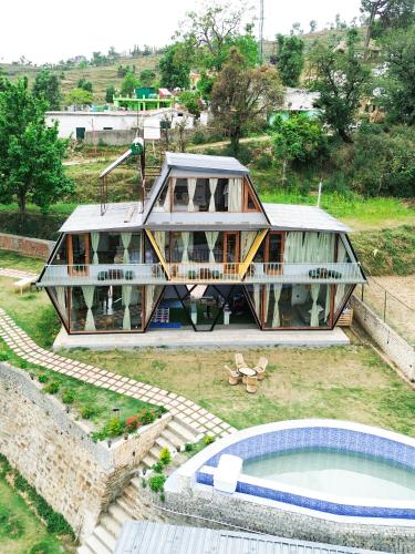 a house with a pool in front of it at Himadvaya- The Himalayan Prism in Almora