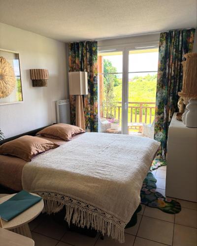 une chambre avec un grand lit et une fenêtre dans l'établissement Le terrier du Green appartement, à Levernois