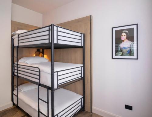 a bunk bed room with three bunk beds and a picture at Limerick City Hotel in Limerick