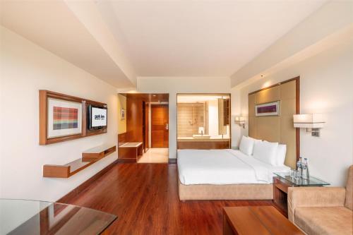 a hotel room with a bed and a couch at Park Inn Gurgaon in Gurgaon