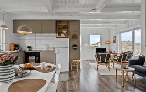 UlfborgにあるNice Home In Ulfborg With Wifiのテーブルと椅子のあるキッチンとリビングルーム