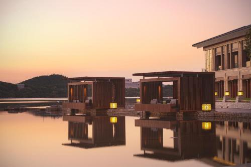 a group of buildings next to a body of water at Yanqi Hotel, Managed by Kempinski in Huairou