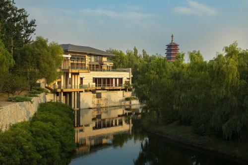 a house next to a river with a building at Yanqi Hotel, Managed by Kempinski in Huairou