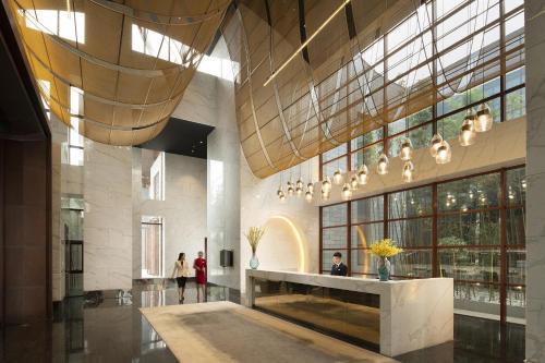 a lobby with people walking in a building at Yanqi Hotel, Managed by Kempinski in Huairou