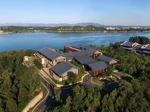 an aerial view of a building with a lake at Yanqi Hotel, Managed by Kempinski in Huairou