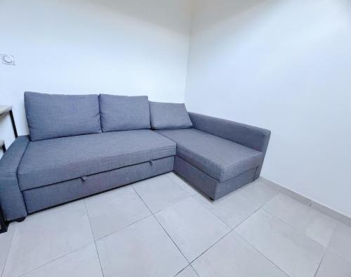 - un canapé bleu dans une chambre dotée d'un mur blanc dans l'établissement Sous les toits du centre-ville, à Narbonne