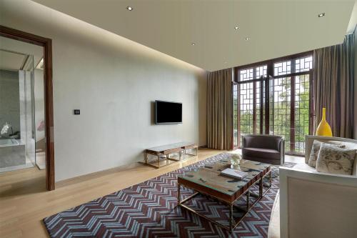 a living room with a table and a tv at Yanqi Hotel, Managed by Kempinski in Huairou