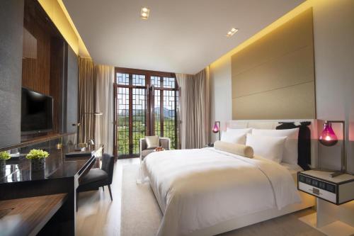 a hotel room with a large bed and a desk at Yanqi Hotel, Managed by Kempinski in Huairou