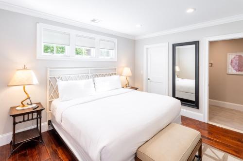 a bedroom with a large white bed and a mirror at The Newport Lofts - 548 Thames Street in Newport