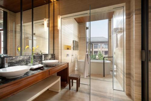 a bathroom with two sinks and a shower at Yanqi Hotel, Managed by Kempinski in Huairou