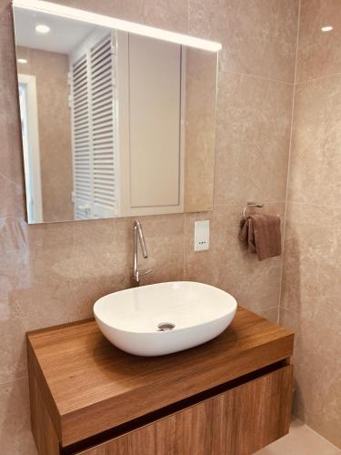 a bathroom with a white sink and a mirror at Seaview Penthouse Xlendi in Xlendi