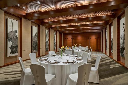 a conference room with white tables and white chairs at Yanqi Hotel, Managed by Kempinski in Huairou