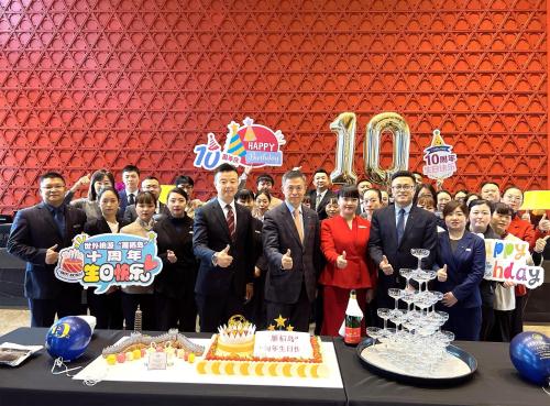 a group of people standing in front of a table with a cake at Yanqi Hotel, Managed by Kempinski in Huairou