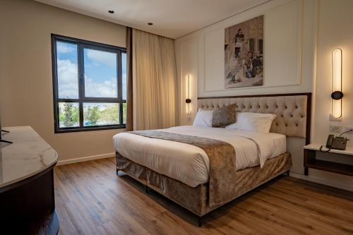 エルサレムにあるLevant Hotelの大きなベッドと窓のある寝室