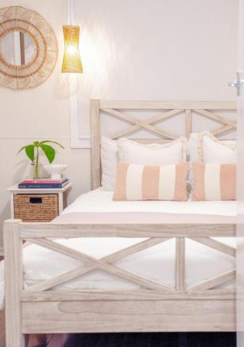 a bedroom with a wooden bed with white sheets and pillows at 'SEAVIEW' - Stunning Coastal Views, Opposite Shaws Bay, Pet Friendly, Sleeps 4 in East Ballina