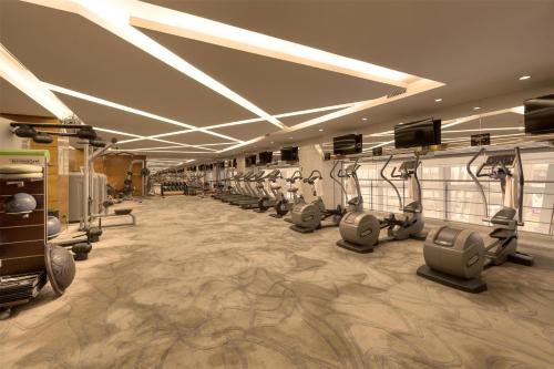 a gym with a row of treadmills and machines at Kempinski Hotel Taiyuan in Taiyuan