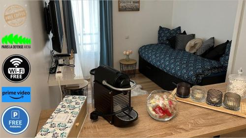 a small living room with a bed and a table at Charming studio in La Défense with free parking in Courbevoie