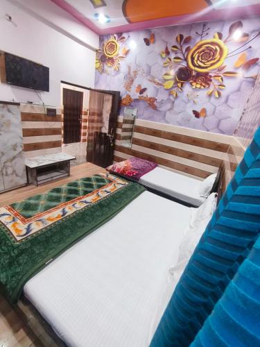 a room with two beds and a mural on the wall at KD Dham family Stay near by Prem Mandir in Vrindāvan