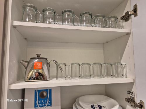 a row of glass jars and a tea kettle on a shelf at aeroperla 15 aéroport casa blanca in Nouaseur