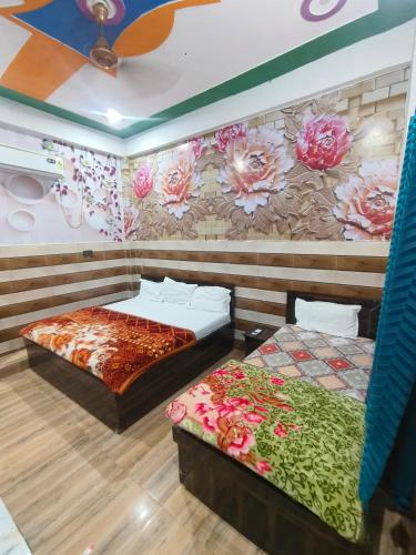 two beds in a room with flowers on the wall at KD Dham family Stay near by Prem Mandir in Vrindāvan