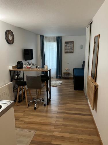 a living room with a desk and a table with chairs at Charming studio in La Défense with free parking in Courbevoie