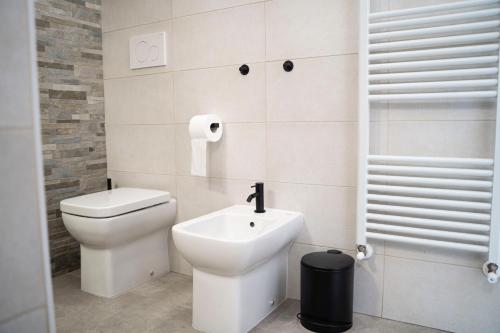 a white bathroom with a toilet and a sink at IL MORO sulla via del Ponte in Sellano