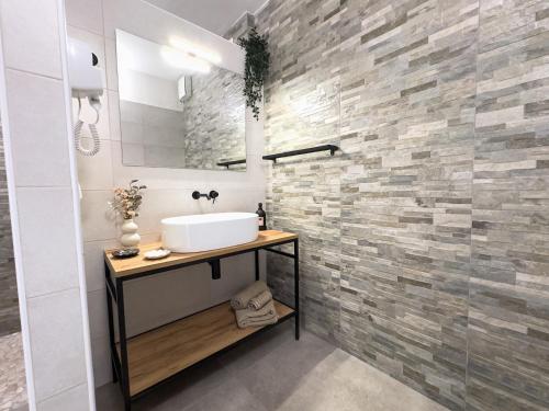 a bathroom with a sink and a stone wall at IL MORO sulla via del Ponte in Sellano