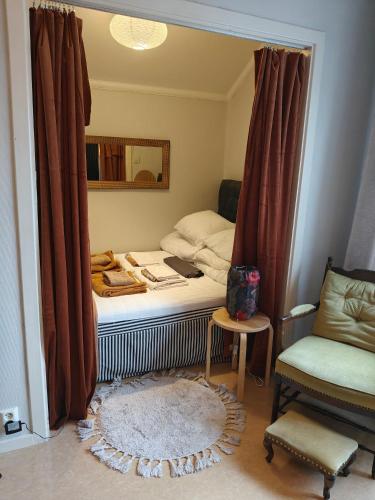 a bedroom with a bed with a mirror and a chair at Central hel lägenhet. Nära till allt. in Umeå