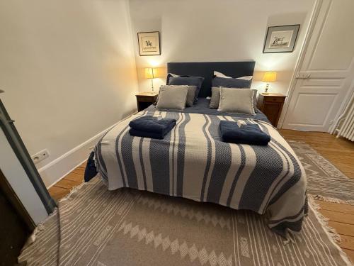 a bedroom with a large bed with a striped blanket at La maison du 18 in Chantilly