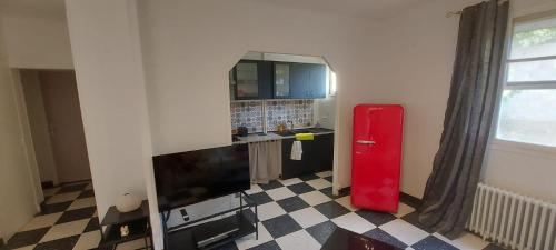 Cette chambre dispose d'un réfrigérateur rouge et d'un sol en damier. dans l'établissement T2 Châteauneuf les Martigues, à Châteauneuf-les-Martigues