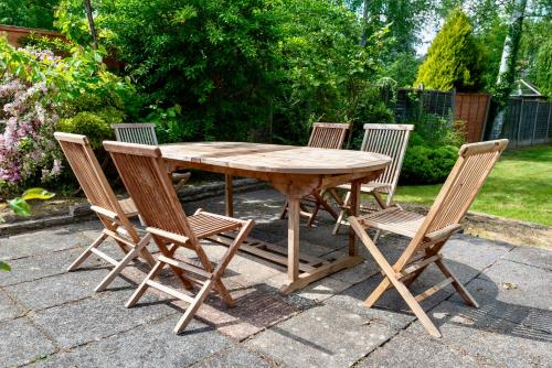 a wooden table with four chairs around it at Modern Double Room with Broadband, Private TV and seating area - Room 4 in Solihull