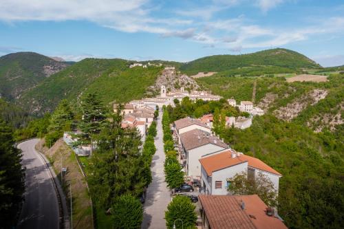 a village in the mountains with a road and houses at IL MORO sulla via del Ponte in Sellano