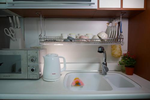 a kitchen counter with a sink and a microwave at Hongdae Sky apartment in Seoul