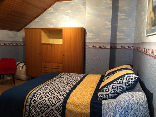 a bedroom with a bed and a wooden cabinet at Villa Belles Rives in Bellerive-sur-Allier