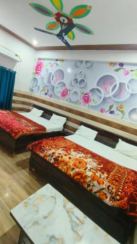 a room with two beds and a wall with a butterfly on it at KD Dham family Stay near by Prem Mandir in Vrindāvan