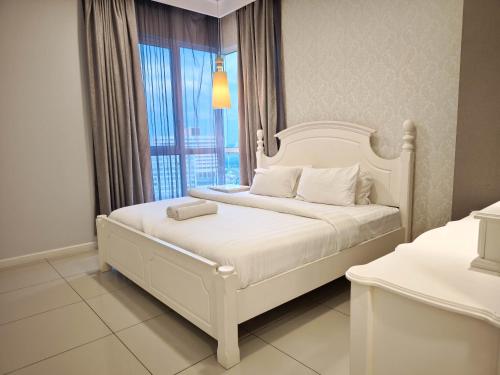 a white bed in a room with a window at The Shore Residences by Amanjiwa in Melaka