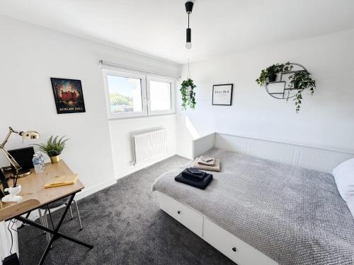 a white bedroom with a bed and a desk at Luxury Nest 10 Guests Free Parking Middlesbrough in South Bank