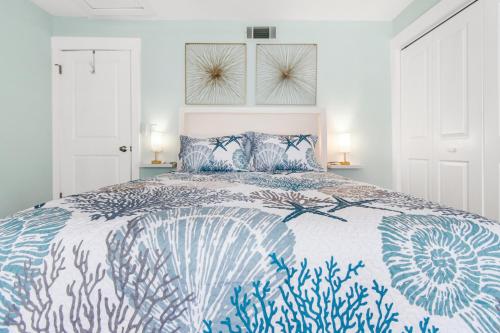 a bedroom with a bed with a blue and white bedspread at Sandy Paws in Navarre