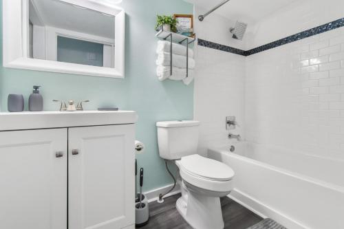 a white bathroom with a toilet and a sink at Sandy Paws in Navarre
