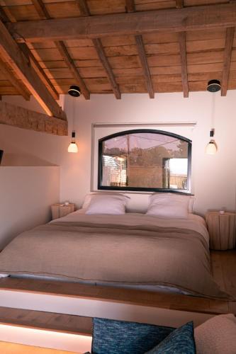 une chambre avec un grand lit avec une fenêtre dans l'établissement Au Chai Bigaroux Saint-Emilion, à Saint-Sulpice-de-Faleyrens