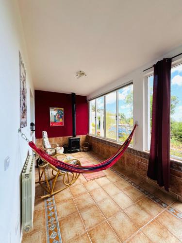 a hammock in a room with red walls and windows at Alojamento Casa Maria in Moncarapacho