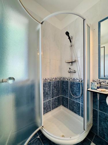 a shower with a glass door in a bathroom at Alojamento Casa Maria in Moncarapacho