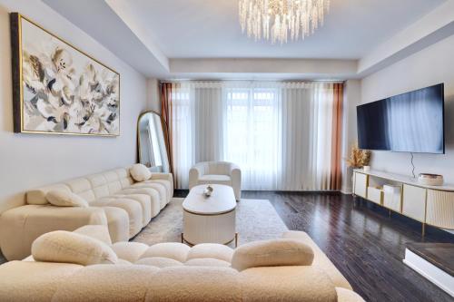a living room with a couch and a tv at Heart of Port Credit, Lakefront, Dining & Shopping in Mississauga