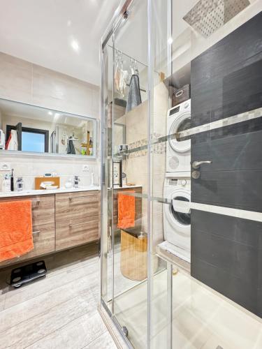 une salle de bain avec une douche en verre et une laveuse et une sécheuse dans l'établissement Charm Azur, Rickeys, à Roquebrune-Cap-Martin