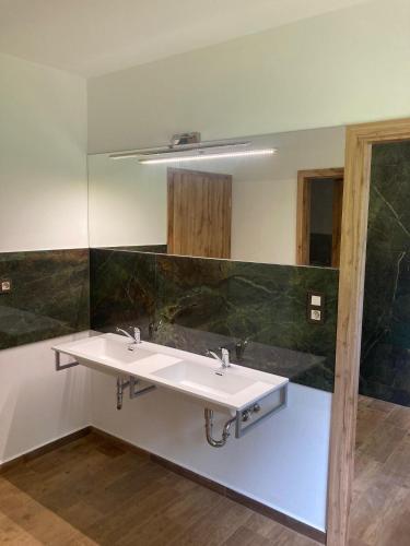 a bathroom with two sinks and a mirror at Apartmány Camping Český les in Lesná
