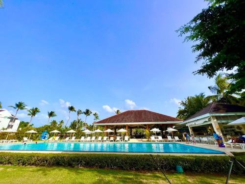 拉斯特拉纳斯Luxury Beachfront 2BR Apt -Prime Location in Playa Bonita的度假村的游泳池，配有椅子和遮阳伞