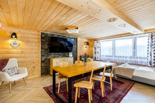 a dining room with a table and a bed at Willa Ciżemka- sauna, tężnia solankowa in Bukowina Tatrzańska